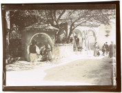 Bosnie. Travnik. Scène de rue : personnages à la fontaine et la tombe du Vizir en arrière plan.