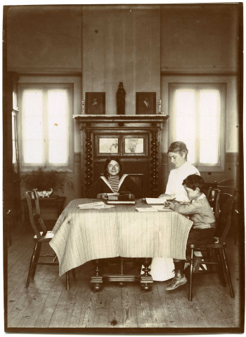 Hauteville-sur-Mer. Intérieur d'un chalet : Mme Chaussemiche et ses deux enfants, Agnès et Jean, assis dans la salle à manger.